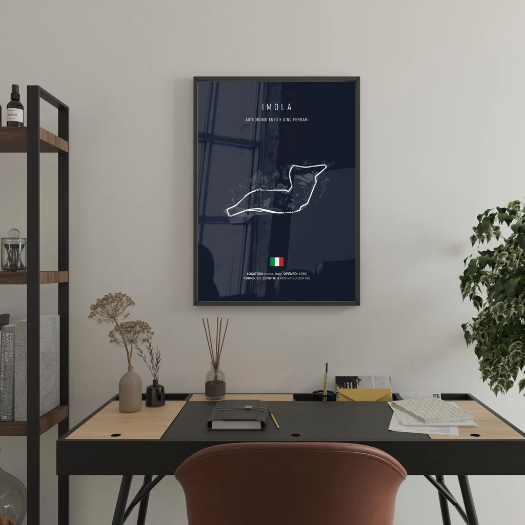 Framed map of Imola on a wall above a desk with office items.